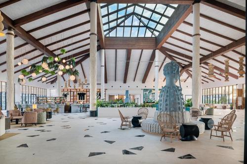 a lobby with chairs and a statue in the middle at Ocean Allure Costa Mujeres - Adults Only - All Inclusive in Costa Mujeres