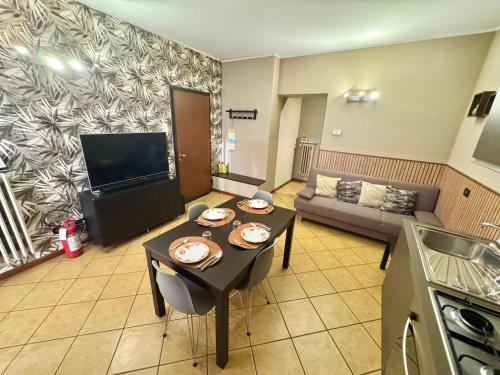 a living room with a table and a couch at CASA di MIRCO -Ampio moderno bilocale per 4 ospiti in Castenedolo