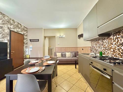 a kitchen and living room with a table and a couch at CASA di MIRCO -Ampio moderno bilocale per 4 ospiti in Castenedolo