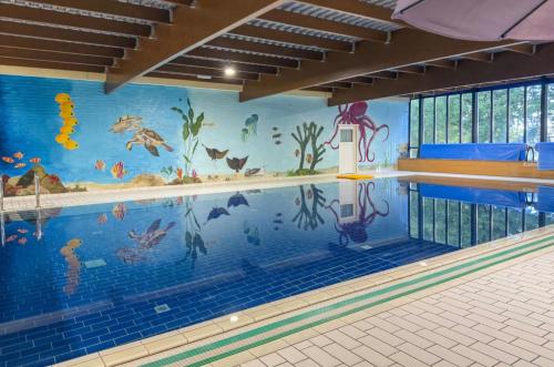 a swimming pool with a mural of animals on the wall at Vakantiehuis 6pers op park 't Broeckhuys in Ewijk groot Zwemplas in het land van Maas & Waal niet voor arbeidsmigranten in Ewijk