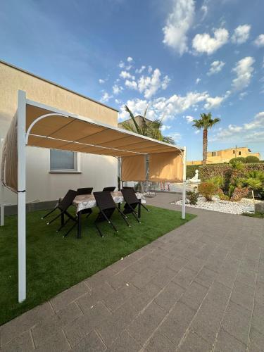 a pavilion with a table and chairs under it at Villa Panama con piscina - Mazara del vallo in Mazara del Vallo