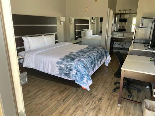 a hotel room with a bed and a desk at Americas Best Value Inn Arlington in Arlington
