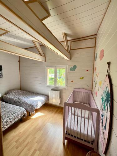 a room with two beds and a crib in it at chalet atypique, Ile chambod in Echallon