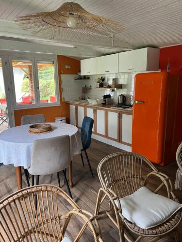 a kitchen with a table and chairs and a refrigerator at chalet atypique, Ile chambod in Echallon
