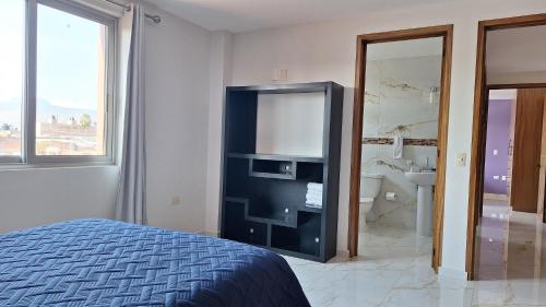 a bedroom with a bed and a tv and a bathroom at Depas Ocampo in Morelia