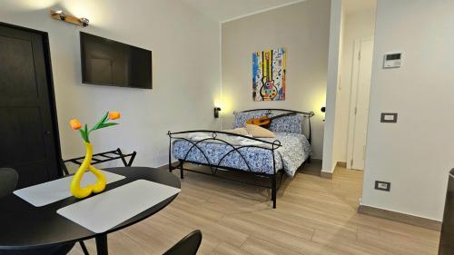 a room with a bed and a table with a vase at Talenti Suites Rome Casa Vacanze in Rome