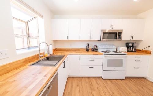 a kitchen with white cabinets and a sink at Newly Remodeled Family Friendly Home in Page