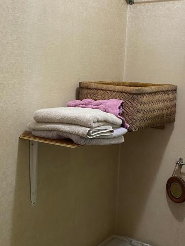a shelf with towels and a basket in a bathroom at 田舎庵 in Hanyu