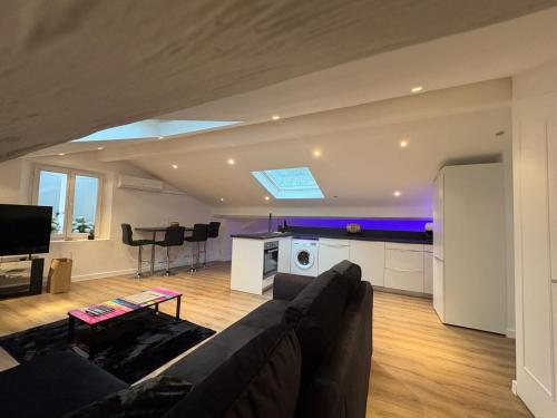 Le Loft Cannes في كان: غرفة معيشة مع أريكة ومطبخ