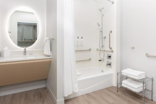 a bathroom with a tub and a sink and a mirror at TownePlace Suites by Marriott Pleasanton in Pleasanton