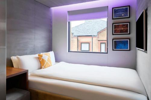 a bedroom with a white bed and a window at Four Points Flex by Sheraton Birmingham Jewellery Quarter in Birmingham
