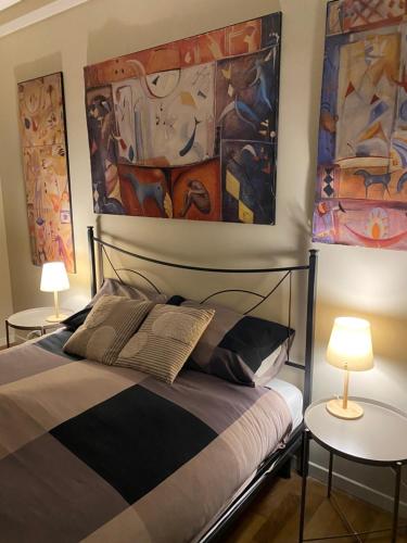 a bedroom with a bed and two tables with lamps at Casa dell'Orso Biella in Biella