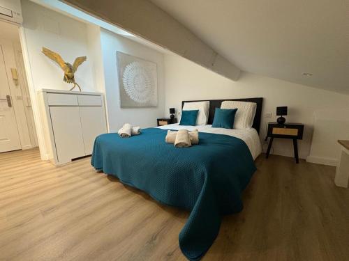 Le Loft Cannes في كان: غرفة نوم بها سرير كبير ذو ملاءات زرقاء