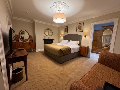 a bedroom with a bed and a table and a couch at Cashel Regency Townhouse in Cashel