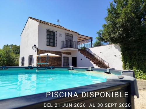 a large swimming pool in front of a house at Casa Rural del Guadalora in Hornachuelos