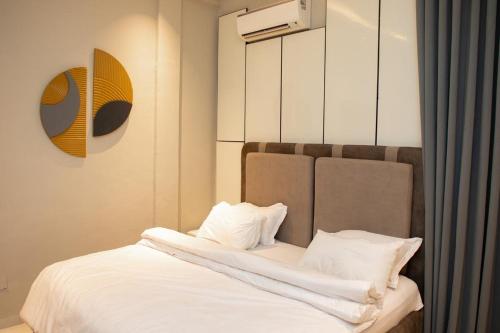 a bedroom with a bed with white sheets and pillows at The Maridoc in Lagos