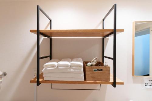 a bathroom with a shelf with towels and a mirror at Fujiyasan in Fujikawaguchiko