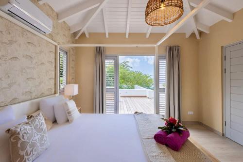 a bedroom with a large white bed and a balcony at Villa Flores Corales 84 - Coral Estate in Willibrordus
