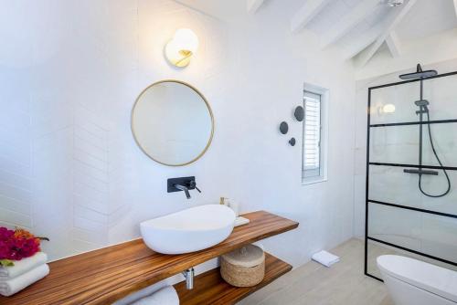 a white bathroom with a sink and a mirror at Villa Flores Corales 84 - Coral Estate in Willibrordus