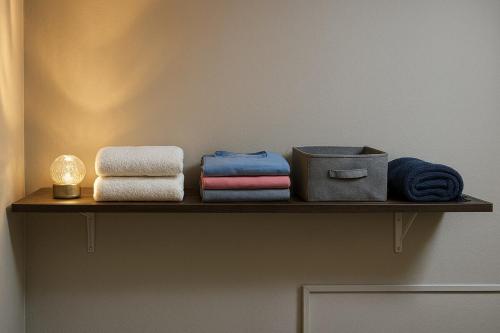 a shelf with towels and a candle on a wall at Studio Palm Garden em Nova Andradina in Nova Andradina