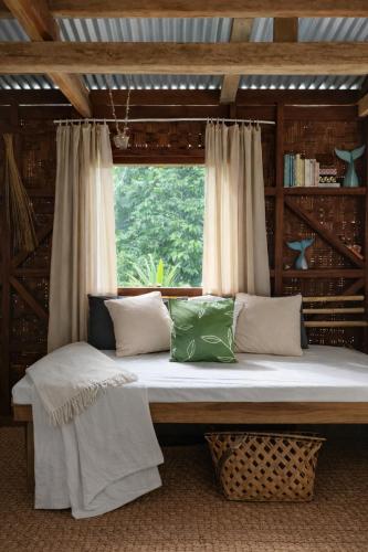 a large bed in a room with a window at Beachfront on Aore Island Private Island Stay in Aimbuei Bay