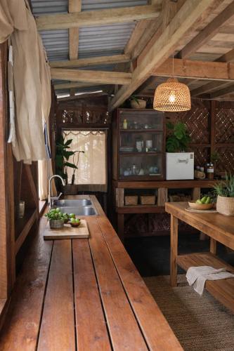 a kitchen with a wooden table and a sink at Beachfront on Aore Island Private Island Stay in Aimbuei Bay