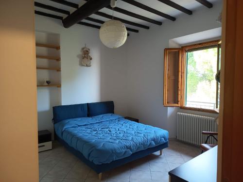 a bedroom with a blue bed and a window at Maria Luisa Home in Poggibonsi