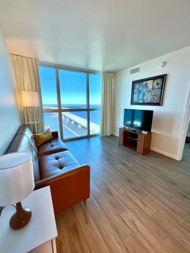 a living room with a couch and a flat screen tv at Stunning Water View Suite in Fort Myers