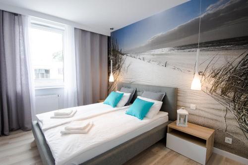a bedroom with two beds and a picture of the beach at Apartament Baltic Park - BEL MARE 2 in Pogorzelica