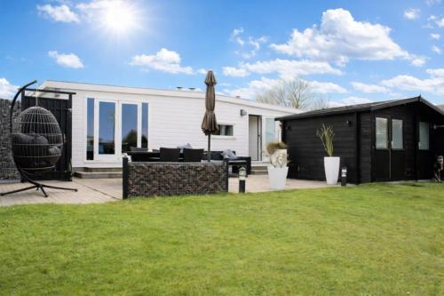 a backyard with a house and an umbrella at Vakantie Chalet T30 - Makkum in Makkum