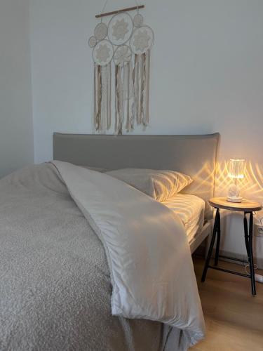 a bedroom with a bed and a table with a lamp at Le Petit Cocon de Pleyben in Pleyben