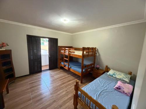 a room with two beds and a bunk bed at Sobrado prainha caioba in Guaratuba