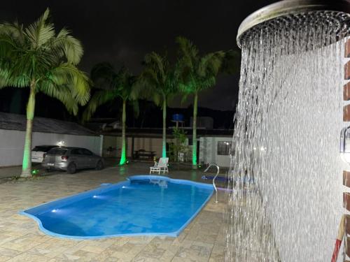 a water fountain in a yard at night at Sobrado prainha caioba in Guaratuba