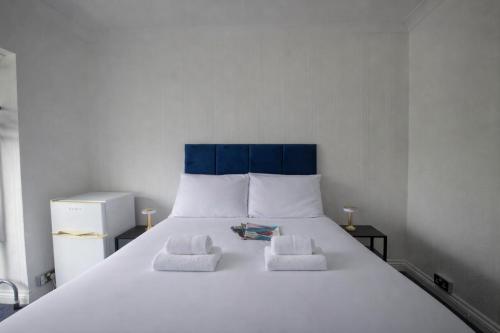 a large white bed with two towels on it at Airport Lodge in Sheldon