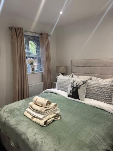 a bedroom with two beds with towels on the bed at Cozy bungalow in Standish
