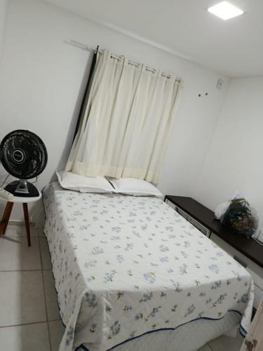 a bedroom with a bed with a window and a fan at Alameda Jardim Serra Negra in Bezerros