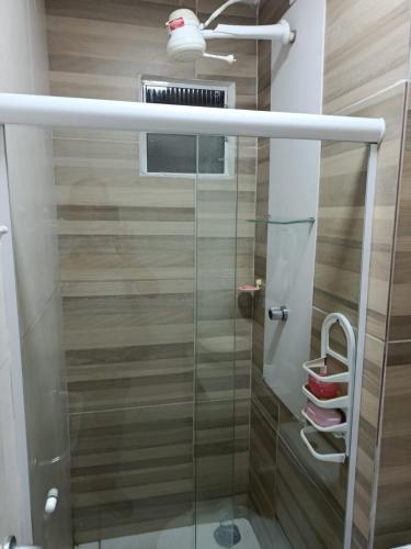 a glass shower in a bathroom with wooden walls at Alameda Jardim Serra Negra in Bezerros