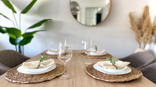 a table with plates of food and wine glasses at MG Playa Flamenca Village in Orihuela Costa