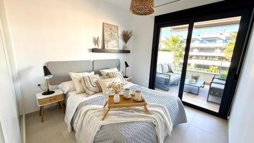 a bedroom with a bed with a table on it at MG Playa Flamenca Village in Orihuela Costa