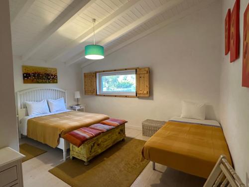 a bedroom with two beds and a window at Courela do Monte Novo in Monte de Jangeis de Cima