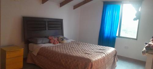 a bedroom with a bed with two stuffed animals on it at casita de campo in Chillán