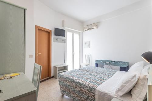 a bedroom with a bed and a desk and a window at Hotel leonardo in Cattolica