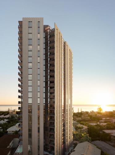 a tall white building with the ocean in the background at Yves Mermaid Beach Apartments by CLLIX in Gold Coast