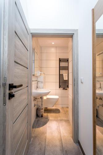 a bathroom with a white toilet and a sink at Conco Leipzig in Leipzig