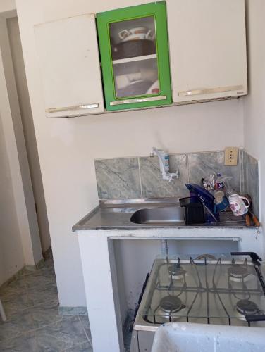 a small kitchen with a stove and a sink at Kitnet Ateneu in Vila Velha