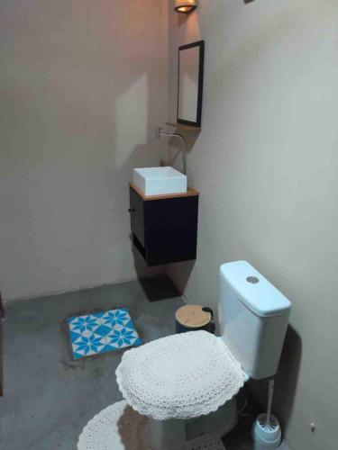 a bathroom with a white toilet and a sink at Dell Ville Cabin in Barreirinhas