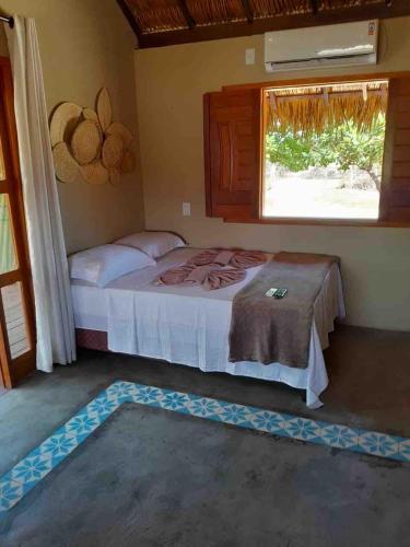 a bedroom with a bed and a window and a rug at Dell Ville Cabin in Barreirinhas