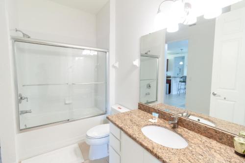 a bathroom with a sink and a toilet and a mirror at 5min Universal Spacious Condo VC101 in Orlando