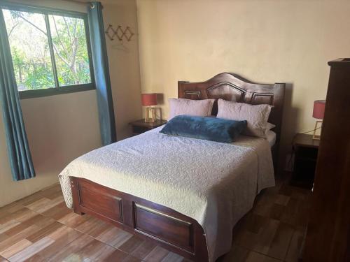 a bedroom with a bed with a blue pillow on it at Jardines del Golfo in Lepanto