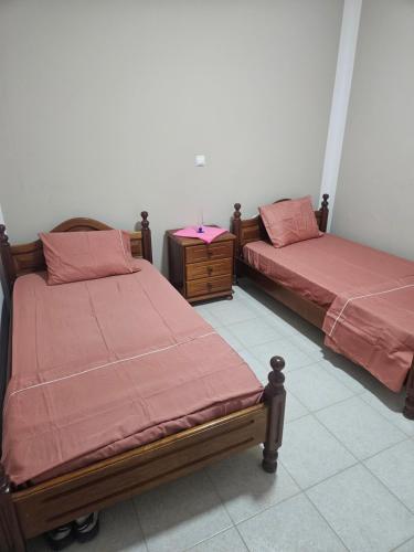 two beds with red sheets in a room at I Love Tanque in Caculi